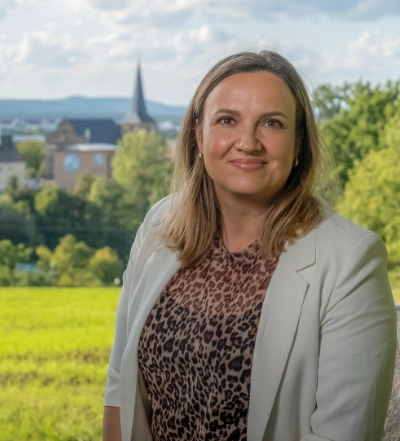 A group of four diverse professionals having a collaborative discussion around a desk with documents, a tablet, and a laptop.