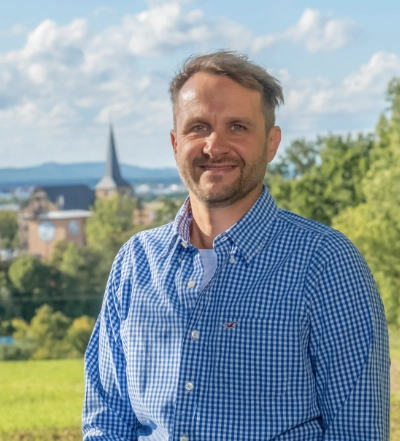 A group of four diverse professionals having a collaborative discussion around a desk with documents, a tablet, and a laptop.