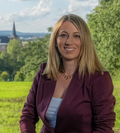 A group of four diverse professionals having a collaborative discussion around a desk with documents, a tablet, and a laptop.