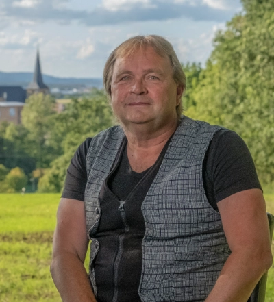 A group of four diverse professionals having a collaborative discussion around a desk with documents, a tablet, and a laptop.