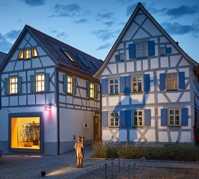 Three professionals standing and discussing documents in a modern office