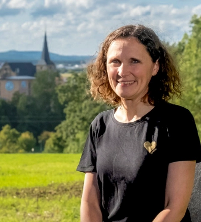 A group of four diverse professionals having a collaborative discussion around a desk with documents, a tablet, and a laptop.