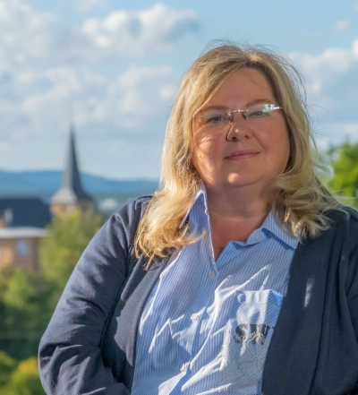 A group of four diverse professionals having a collaborative discussion around a desk with documents, a tablet, and a laptop.