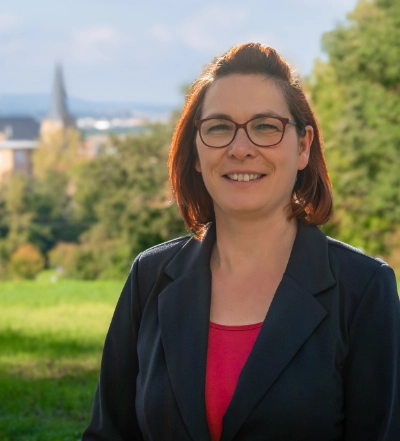 A group of four diverse professionals having a collaborative discussion around a desk with documents, a tablet, and a laptop.