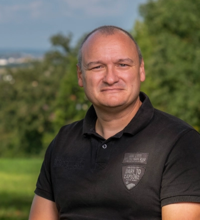 A group of four diverse professionals having a collaborative discussion around a desk with documents, a tablet, and a laptop.