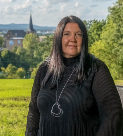 A group of four diverse professionals having a collaborative discussion around a desk with documents, a tablet, and a laptop.