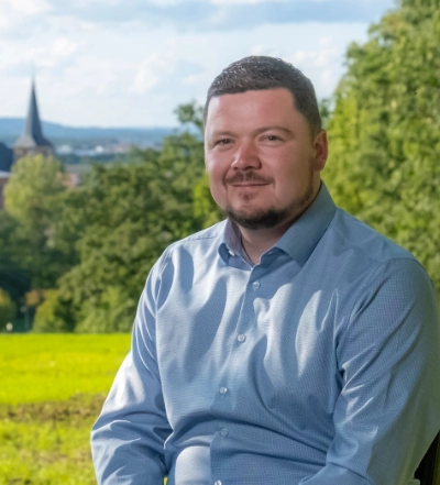A group of four diverse professionals having a collaborative discussion around a desk with documents, a tablet, and a laptop.