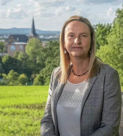 A group of four diverse professionals having a collaborative discussion around a desk with documents, a tablet, and a laptop.