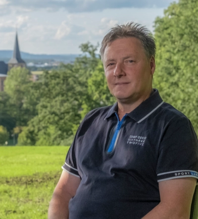A group of four diverse professionals having a collaborative discussion around a desk with documents, a tablet, and a laptop.
