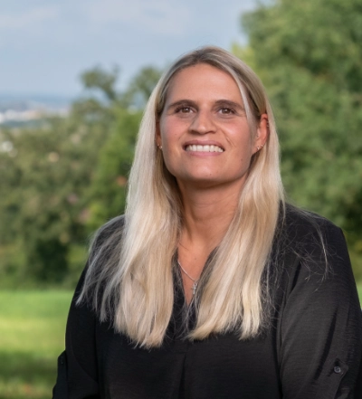 A group of four diverse professionals having a collaborative discussion around a desk with documents, a tablet, and a laptop.